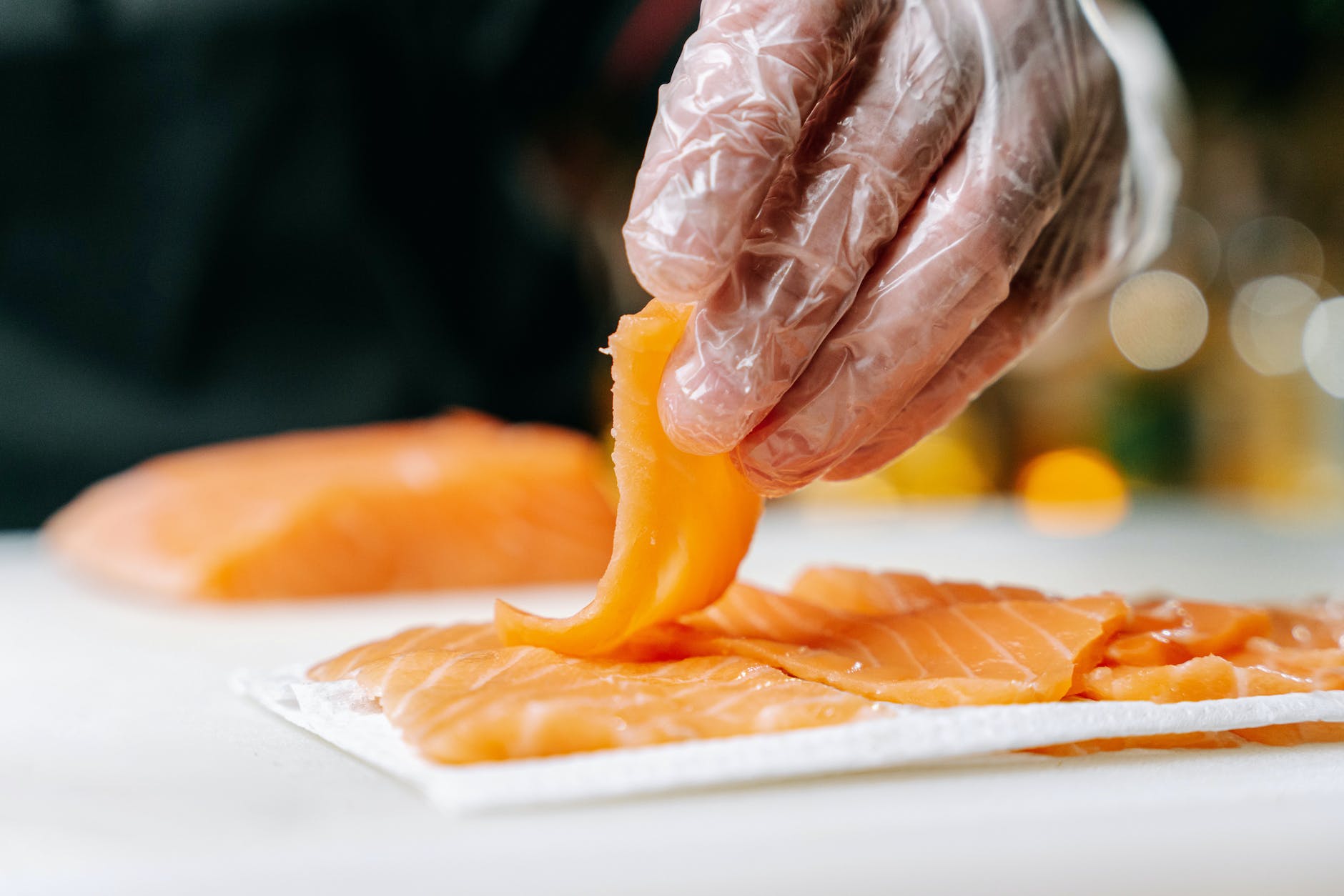 a person holding a slice of salmon